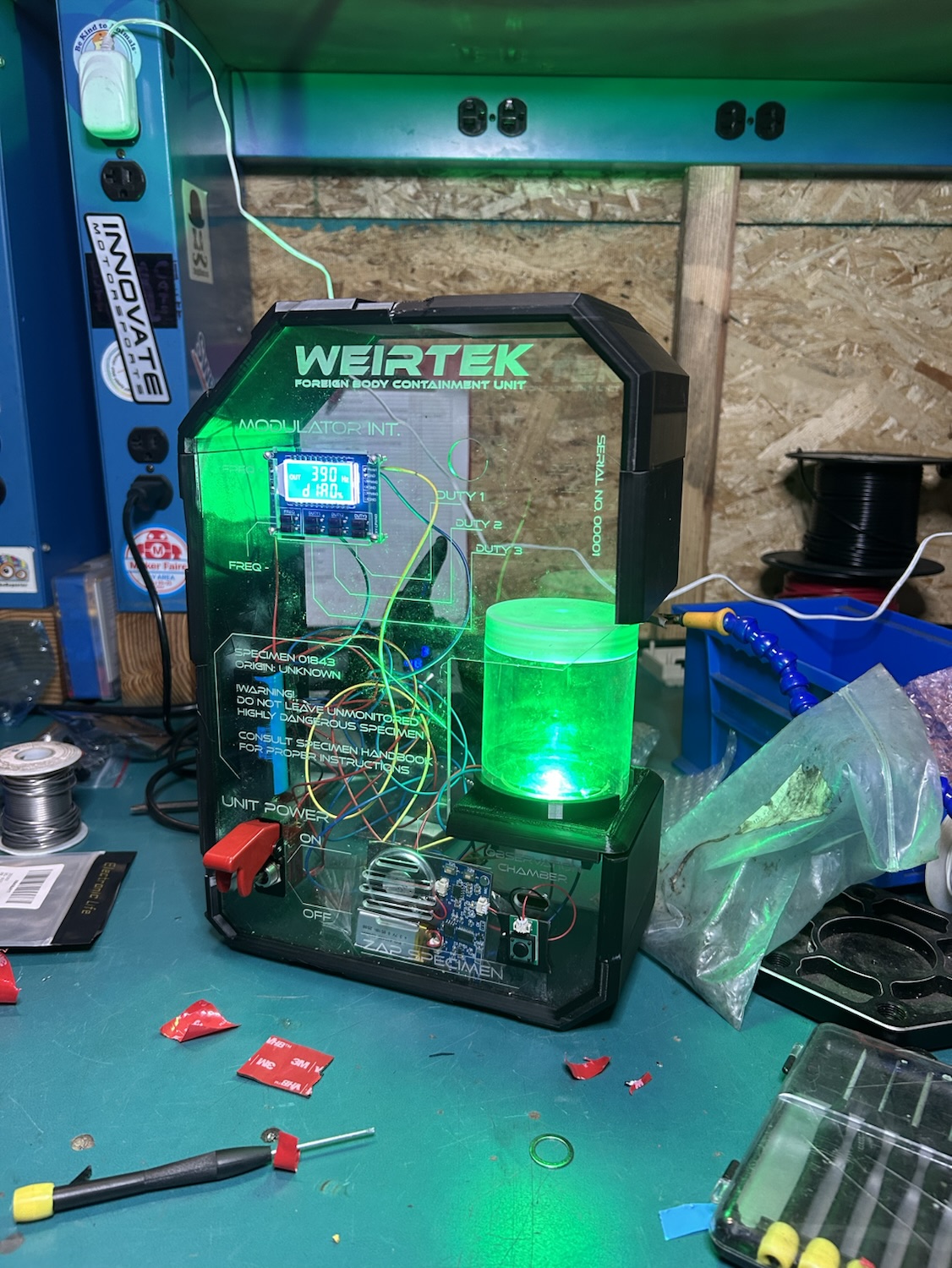 Specimen Lamp glowing green with exposed electronics