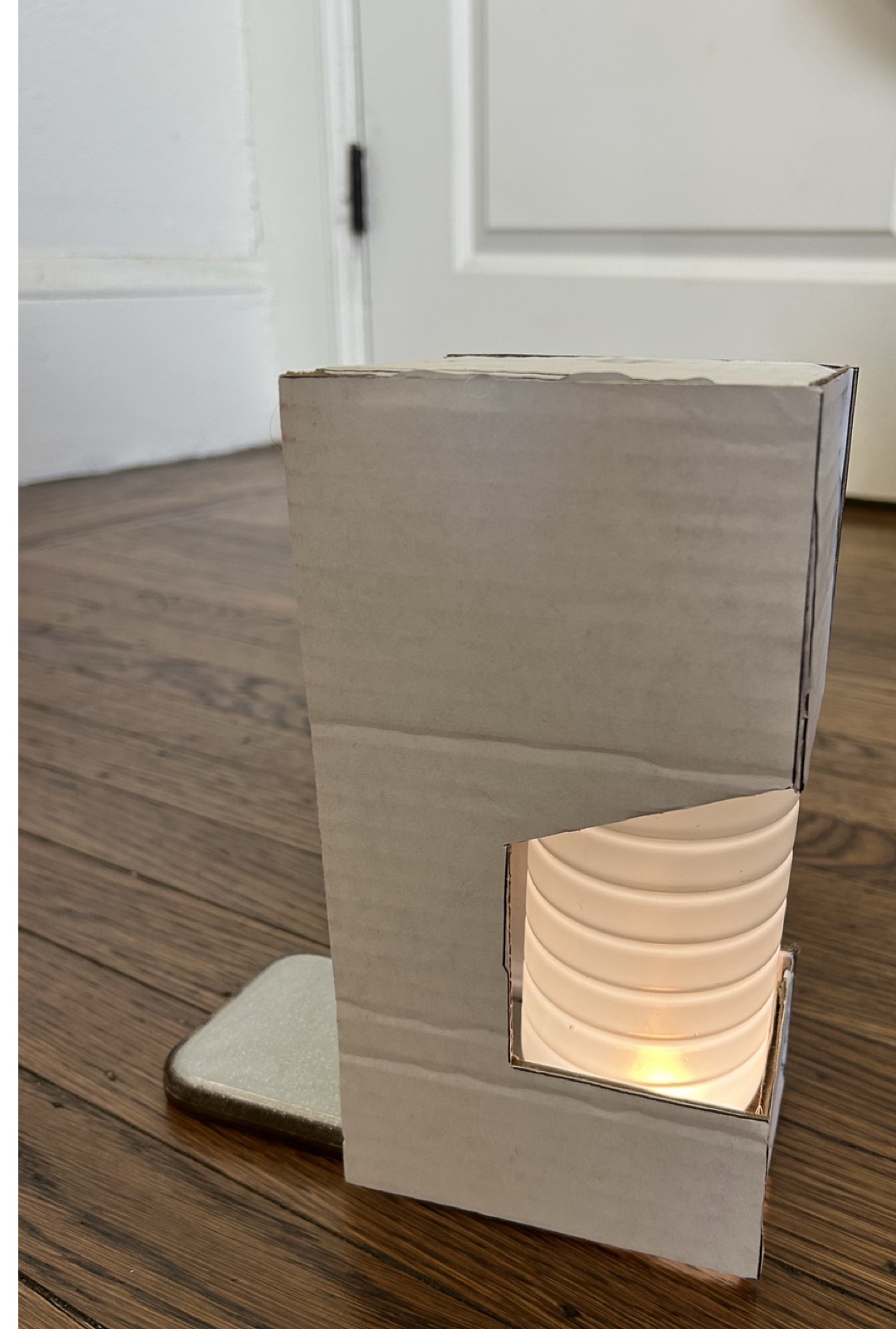 Lit cardboard mockup of the Specimen Lamp